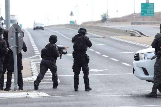 Soldados israelenses tomam posição enquanto um carro se aproxima após uma infiltração em massa de homens armados do Hamas vindos da Faixa de Gaza - (crédito: Reuters)